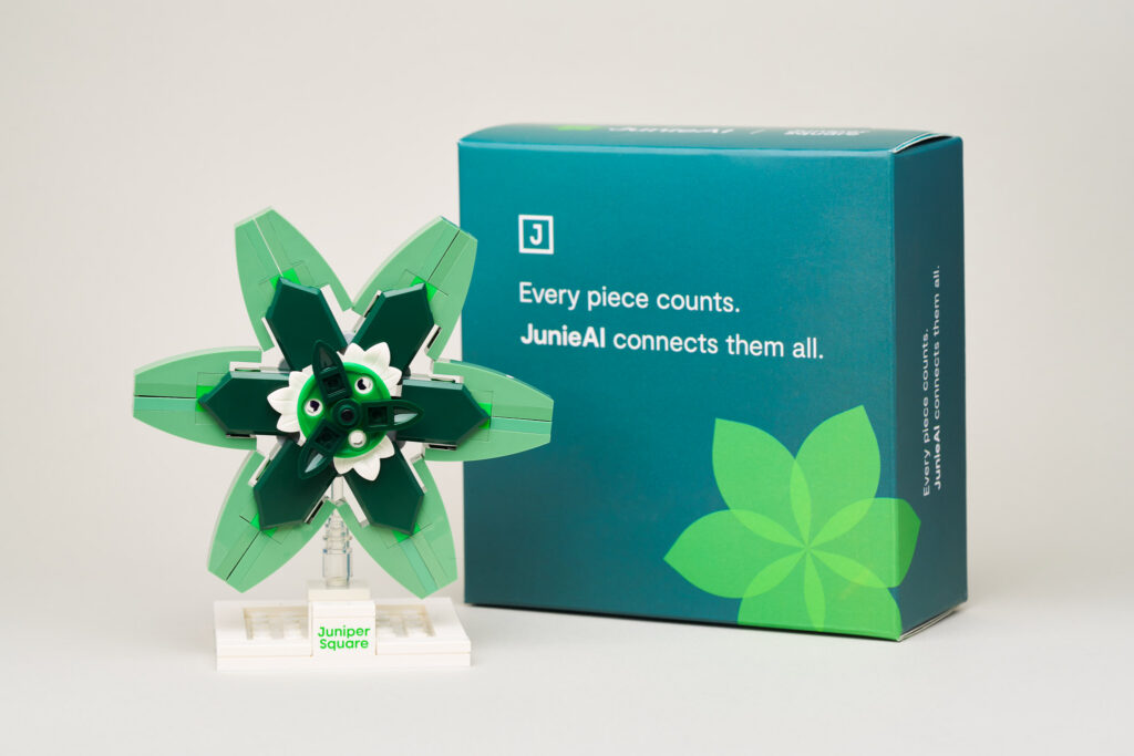 A custom green-branded building brick kit featuring a green box with a white gear graphic and a small assembled green gear model next to it.